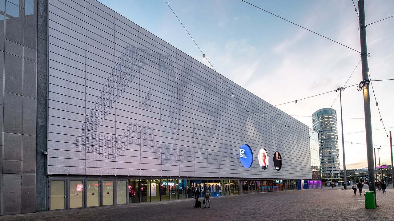 The perforated silver facade of AFAS Live at dusk in Amsterdam Zuidoost